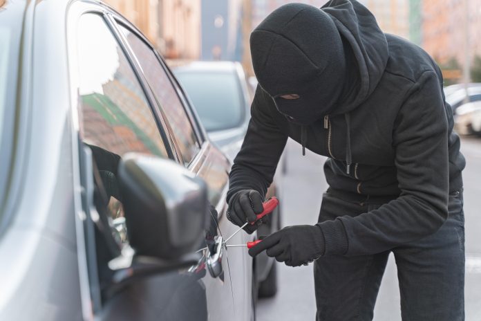 close up man trying break into car